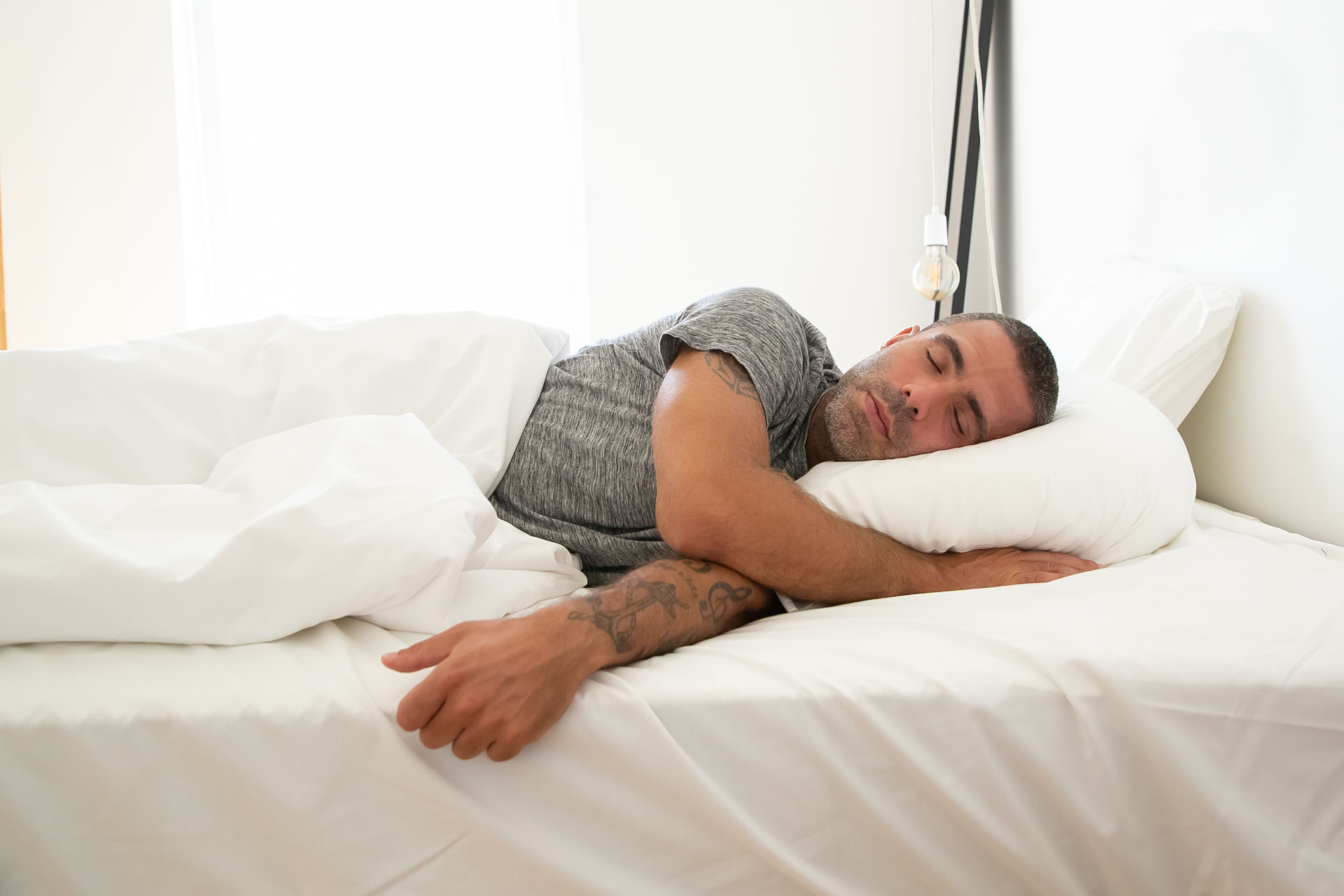Man resting in a bright bedroom
