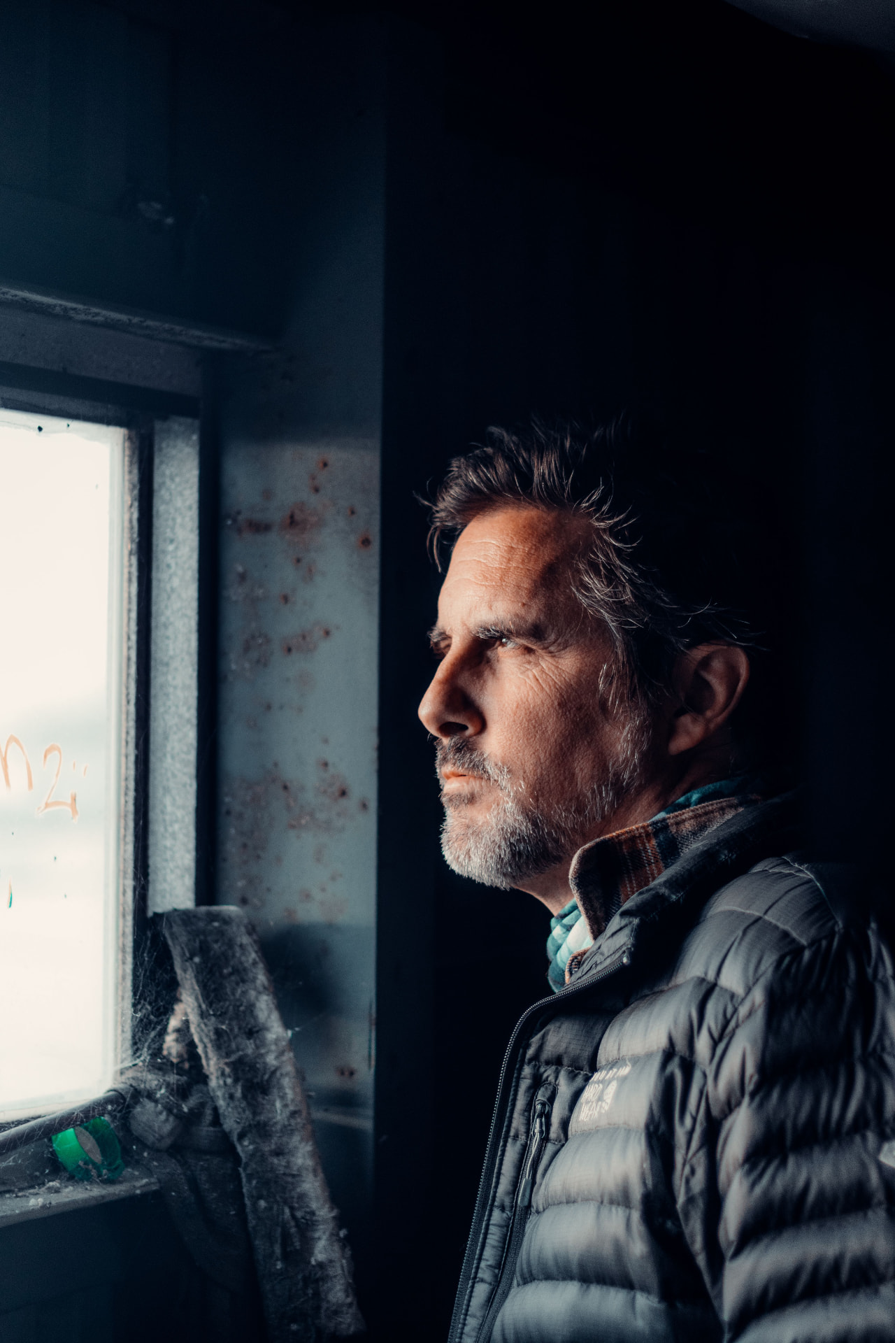 Pensive middle-aged man looking out of a window